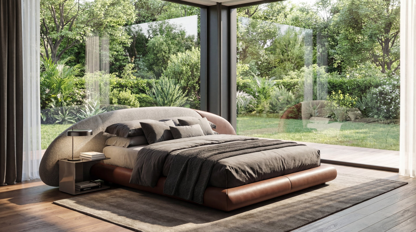 Modern bedroom with a large bed and side tables, featuring a view of greenery outside.