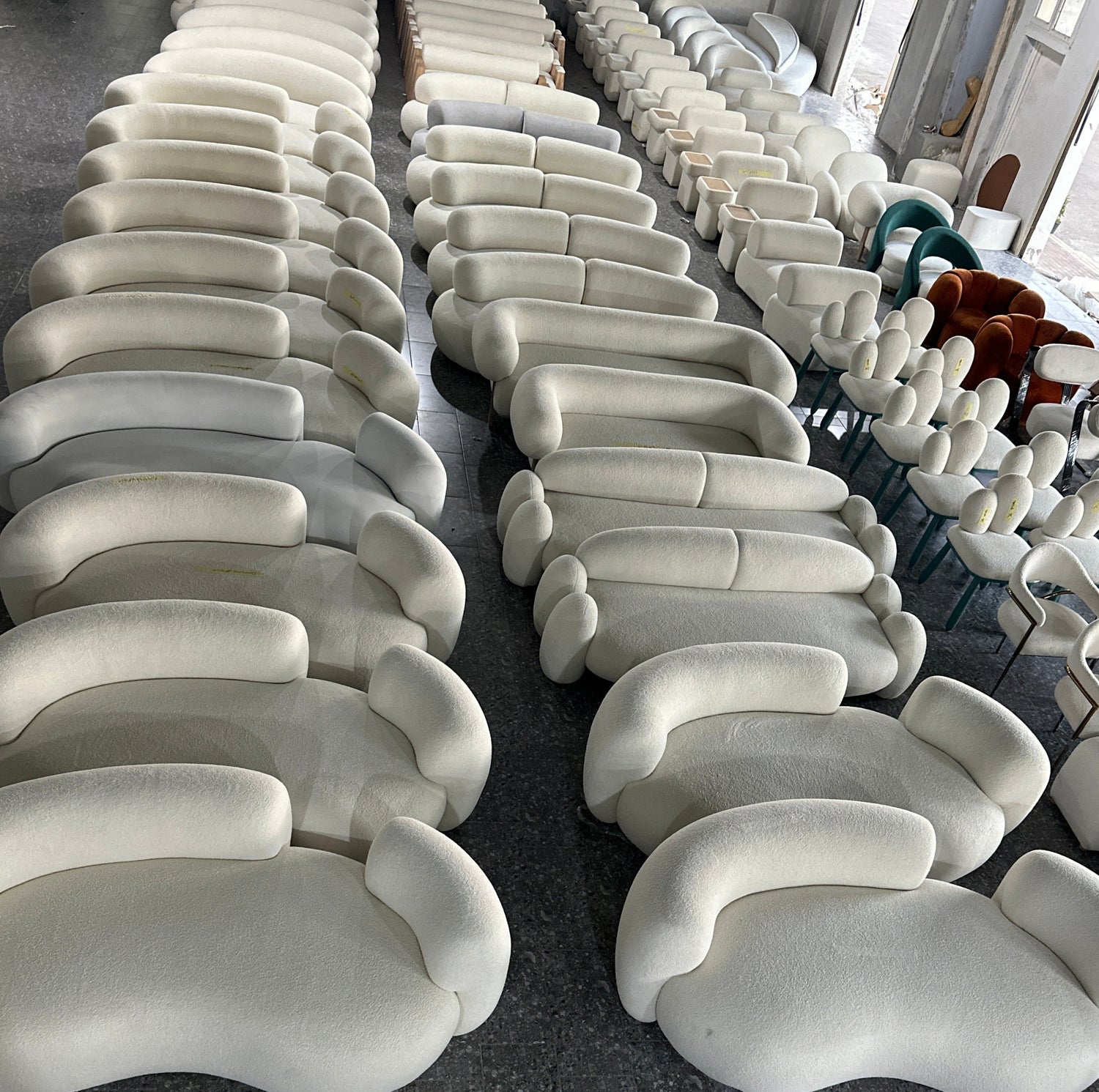 Multiple white curved chairs arranged in a showroom setting with 'FURX' branding.