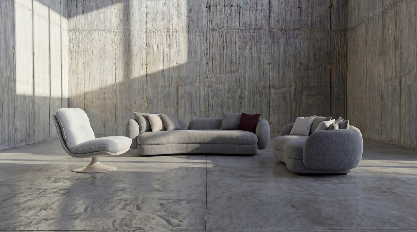 Modern gray sofa set in a minimalistic room with concrete walls and floor.