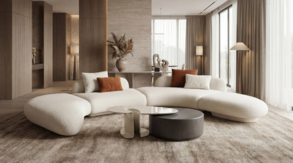 Modern living room with a white sectional sofa, coffee table, and decorative elements.